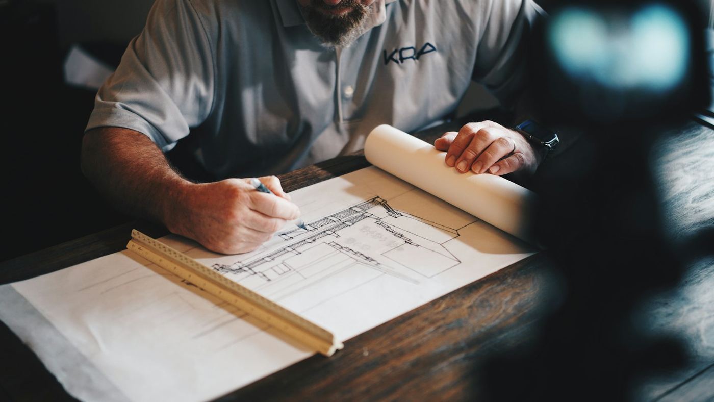 Architectural blueprints and a rolled plan on a desk