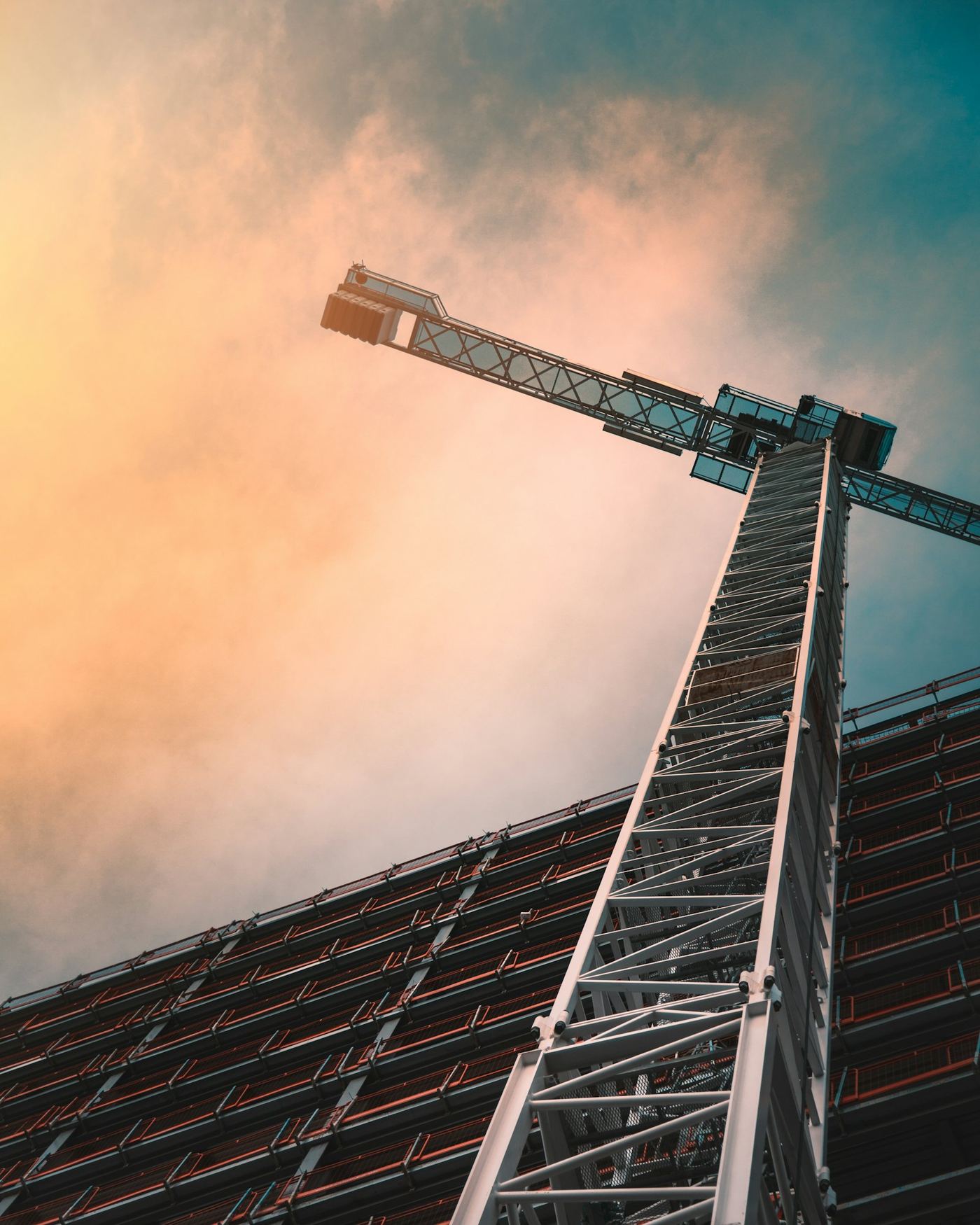 A tower crane rising against a dramatic sky