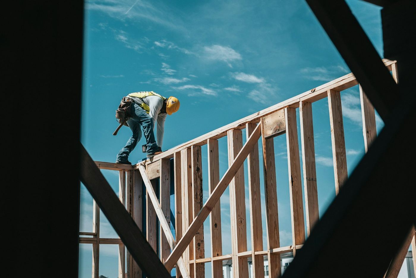 A construction worker on a timber frame high above the street